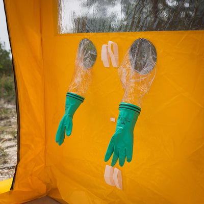 A 3/4 view of the decontamination shower's integrated glove system that allows an outside user to utilize the shower's spray gun.