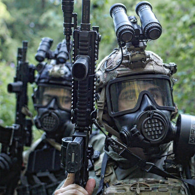 Head on shot of two soldiers in full tactical equipment, wearing CM-8M gas masks with their helmets and holding assault rifles.